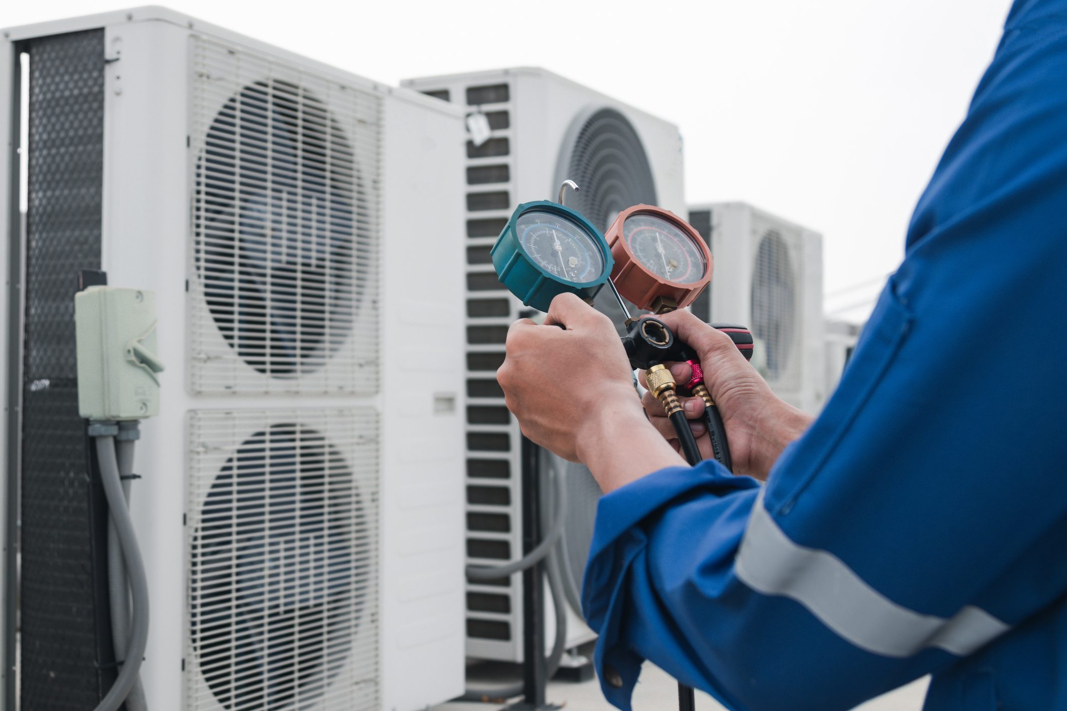 HVAC technician checking air conditioning pressure gauges