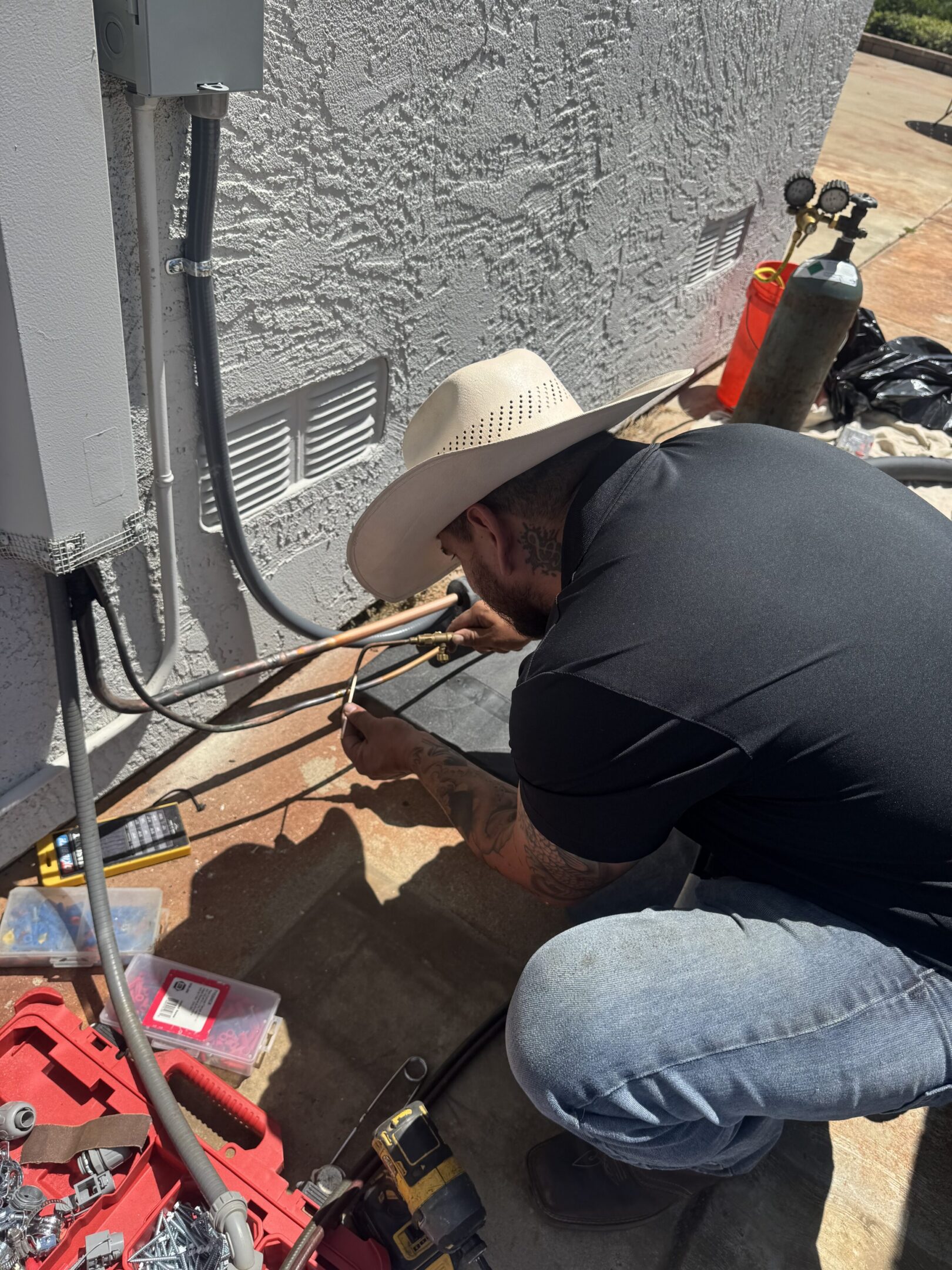 Person in cowboy hat repairing outdoor utility lines