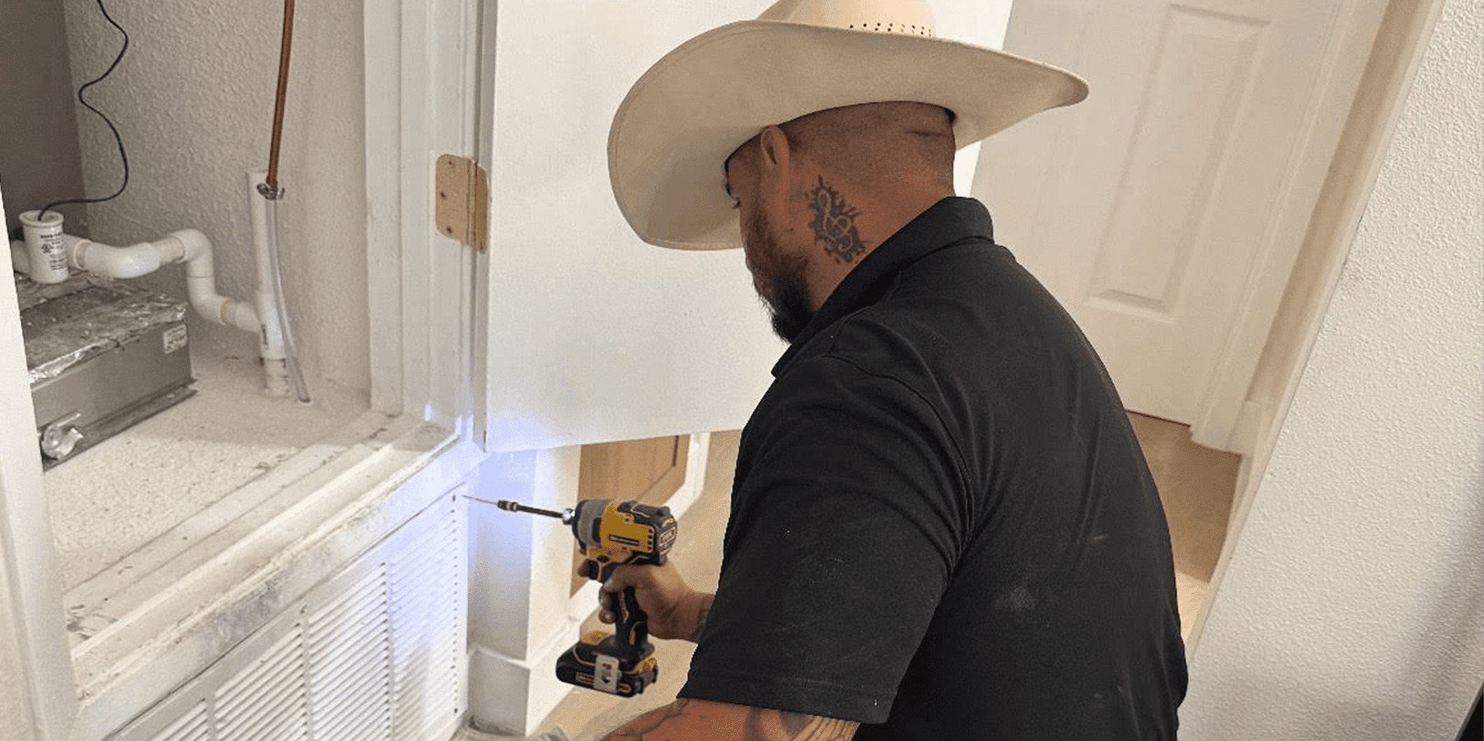 Technician in cowboy hat drilling wall vent