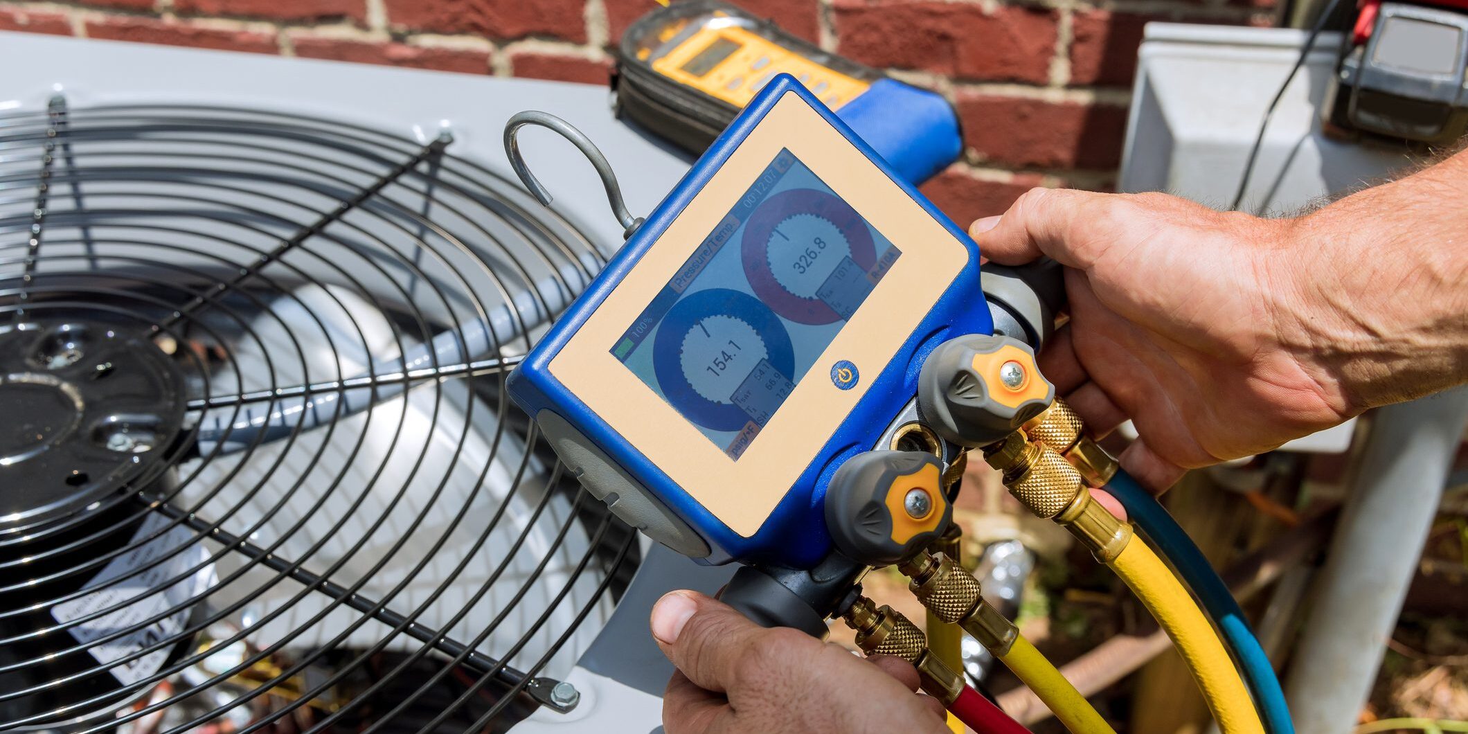 Technician using manifold gauges on air conditioner