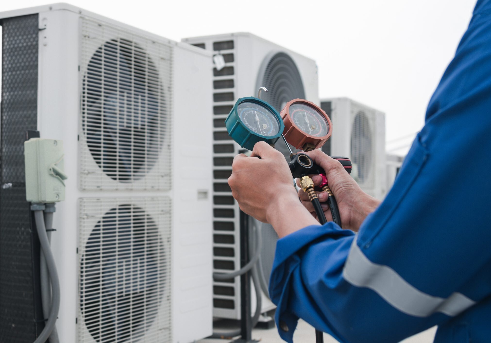 HVAC technician checking air conditioning pressure gauges