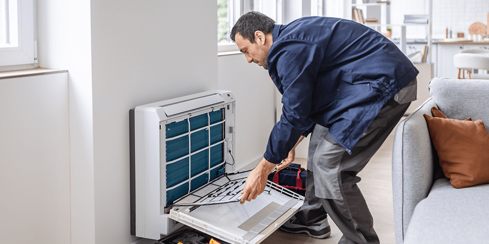 Technician repairing wall-mounted indoor air conditioner