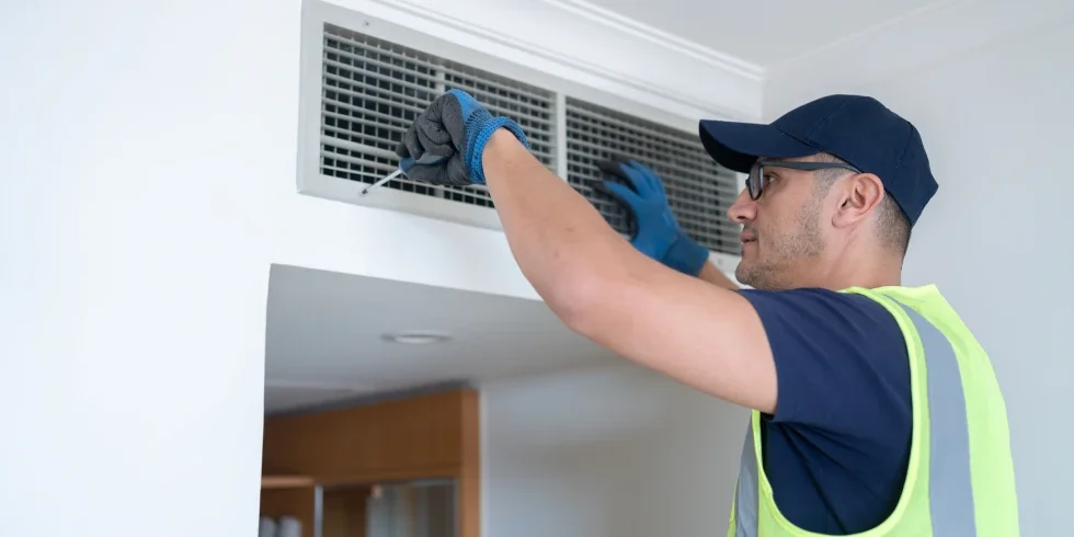 Worker fixing ceiling ventilation system
